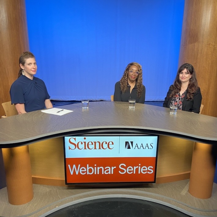 Panelists are sitting around a round table as they film a webinar