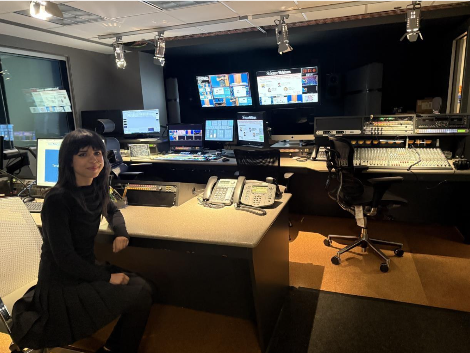 Yamina is standing in front of filming monitors